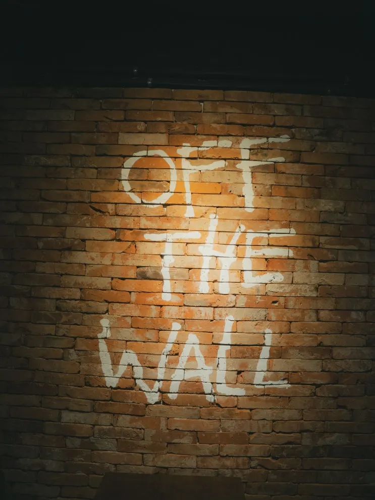 Off The Wall painted brick sign inside its Hapjeong vinyl bar